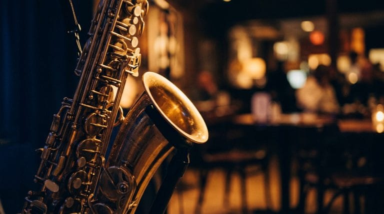 Golden saxophone with keys in sharp focus against blurred jazz club stage lights