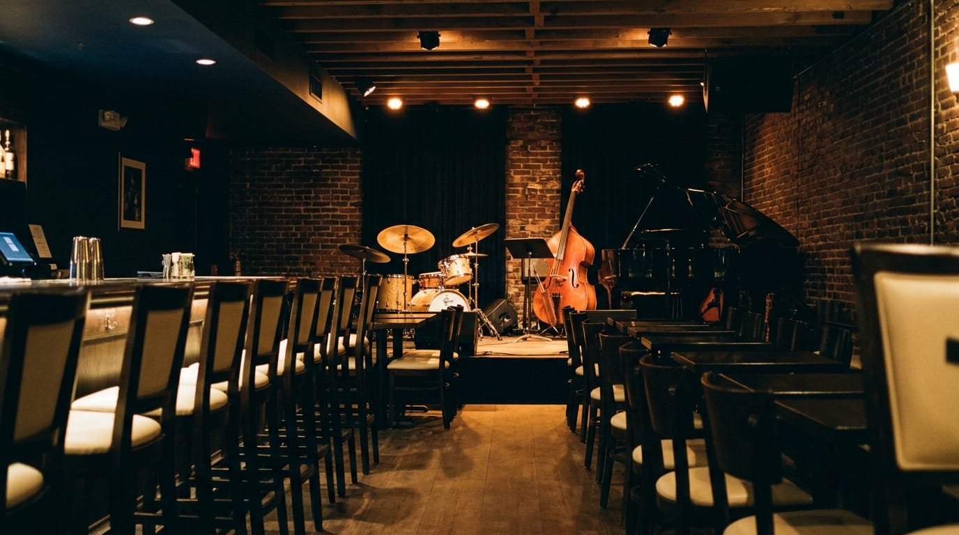 Intimate jazz club with exposed brick, drum kit, upright bass, and stage lighting