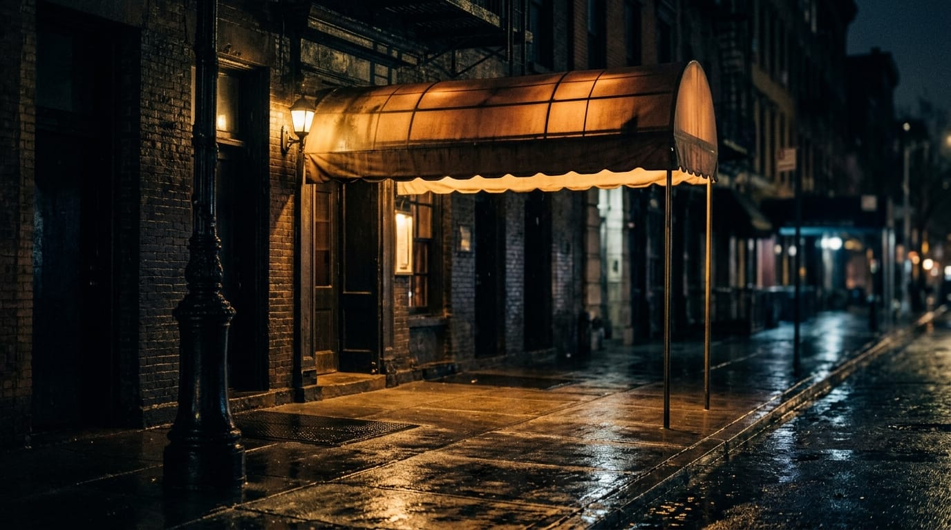 Moody nighttime jazz club entrance with warm golden awning on wet cobblestone street