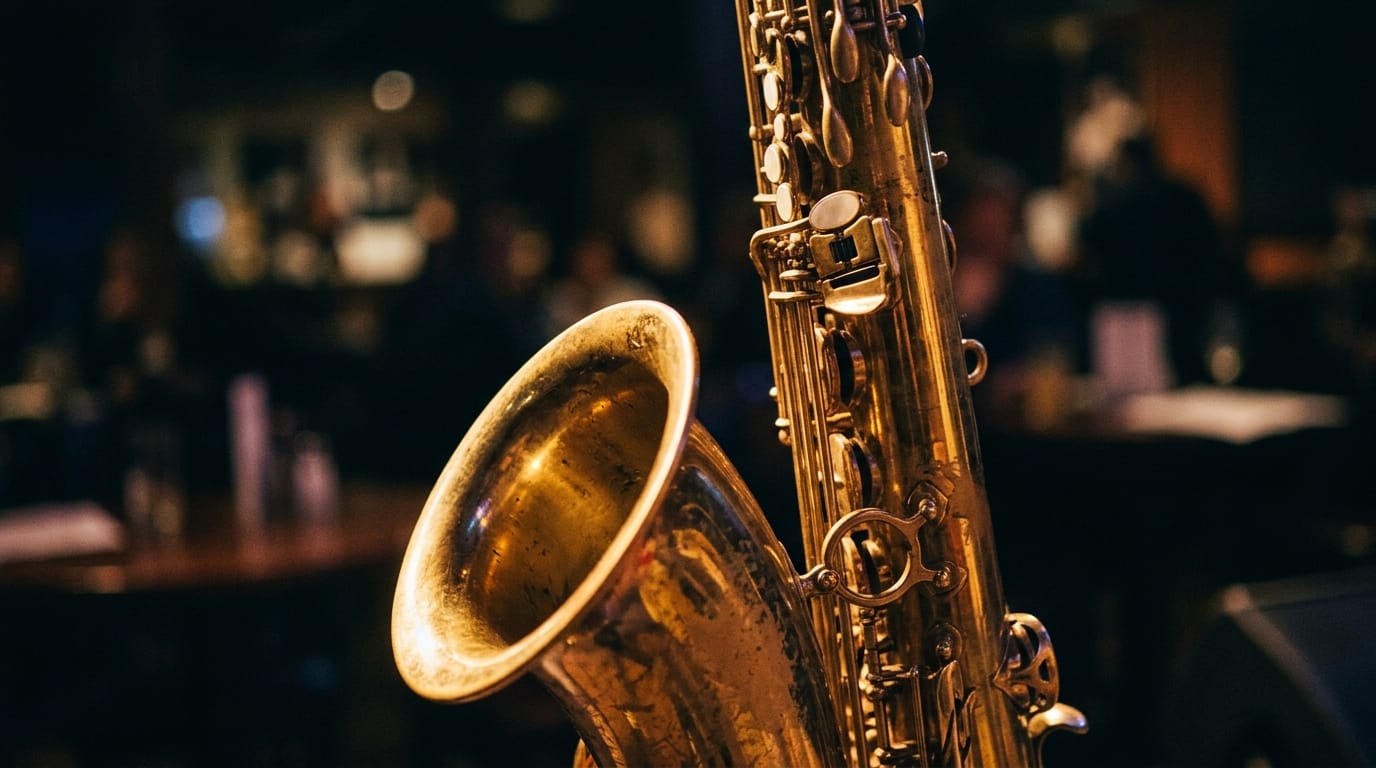 Golden saxophone with keys in sharp focus, blurred jazz club audience in background