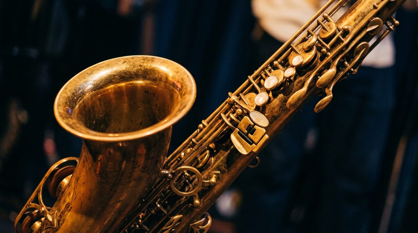Close-up of polished brass saxophone with pearl keys and bell against dark background