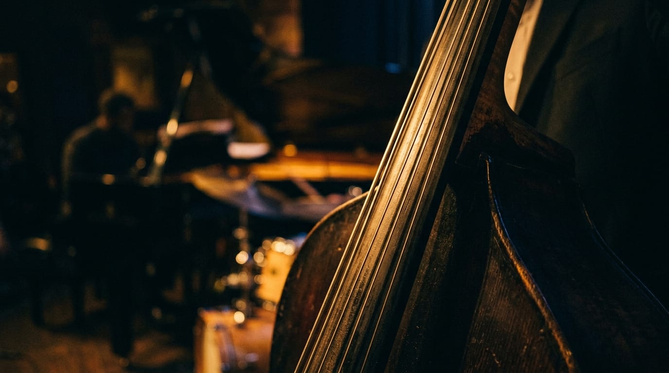 Close-up of upright bass strings in warm stage lighting during jazz performance