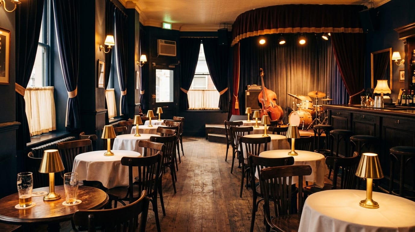 Elegant jazz club interior with stage, upright bass, drums, intimate dining tables, warm lighting