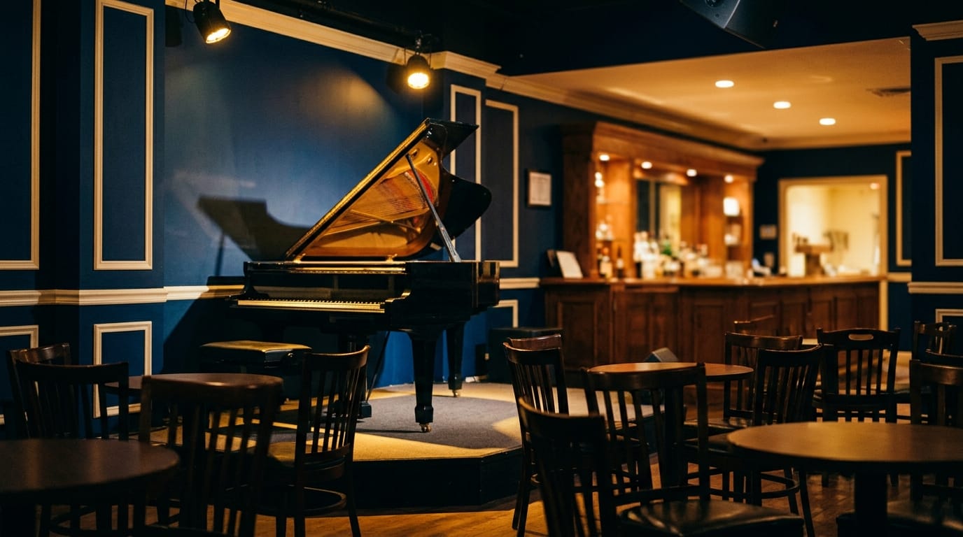 Grand piano on stage in intimate jazz club with blue walls and warm lighting