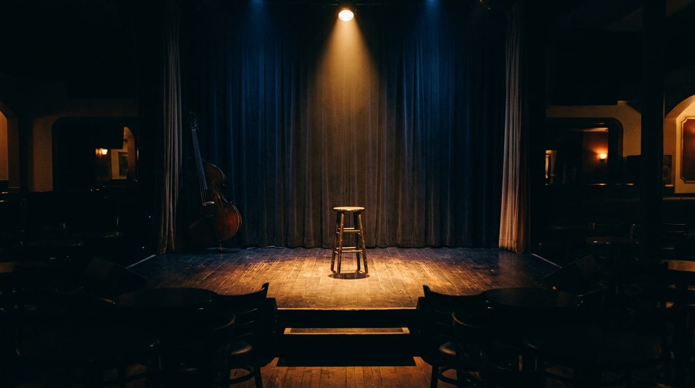 Empty jazz club stage with spotlight, wooden stool, cello, blue curtains, intimate venue atmosphere