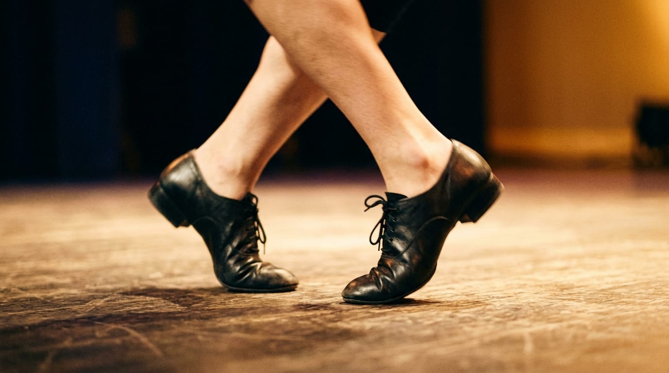 Dancer's feet in black leather jazz shoes performing on wooden stage floor