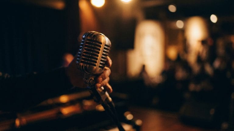 Vintage microphone on stage with warm stage lights and blurred jazz club atmosphere